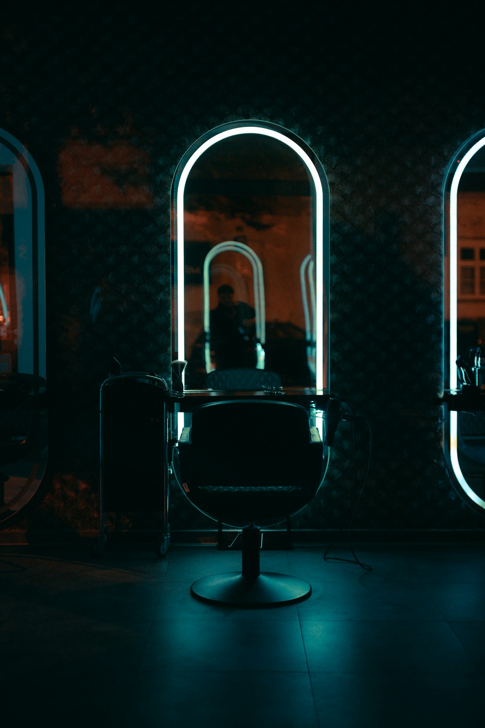 Kemerli aynanın önünde salon koltuğu ve yumuşak neon ışık